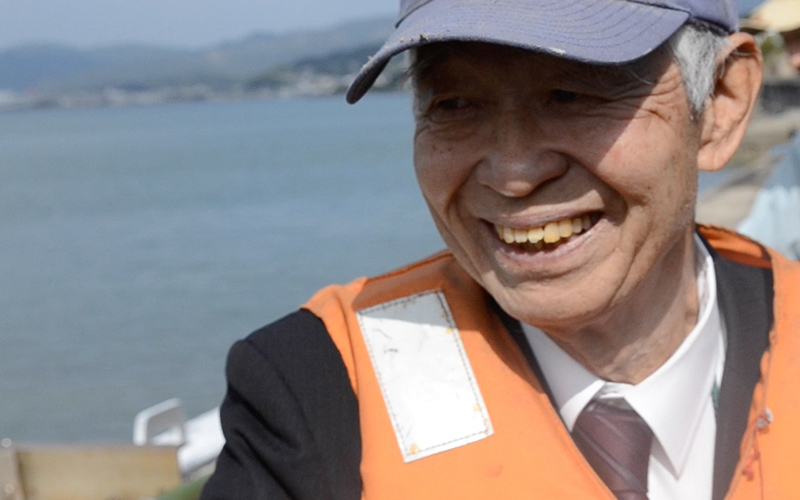 襷（タスキ）ライフジャケットで助かった。山と海に囲まれた坂の町、広島の尾道にある浦島漁港では、 2010年にライフジャケットによって2人のいのちが助かりました。ライフジャケットを着ていた背景には、ライフガードレディース(LGL)の活躍もあり、下見さんと吉岡さんにそれぞれ別の船で起きた落水時の体験を伺いました。